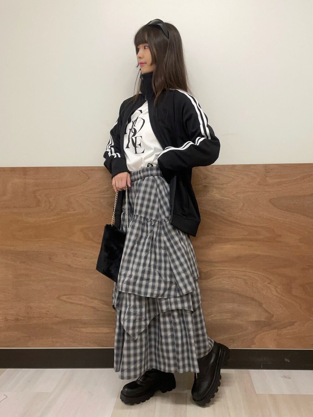 ブラック系のブーツ、グレー系のスカート、ホワイト系のTシャツ/カットソーを着用したレディースの秋コーディネートの3枚目の写真