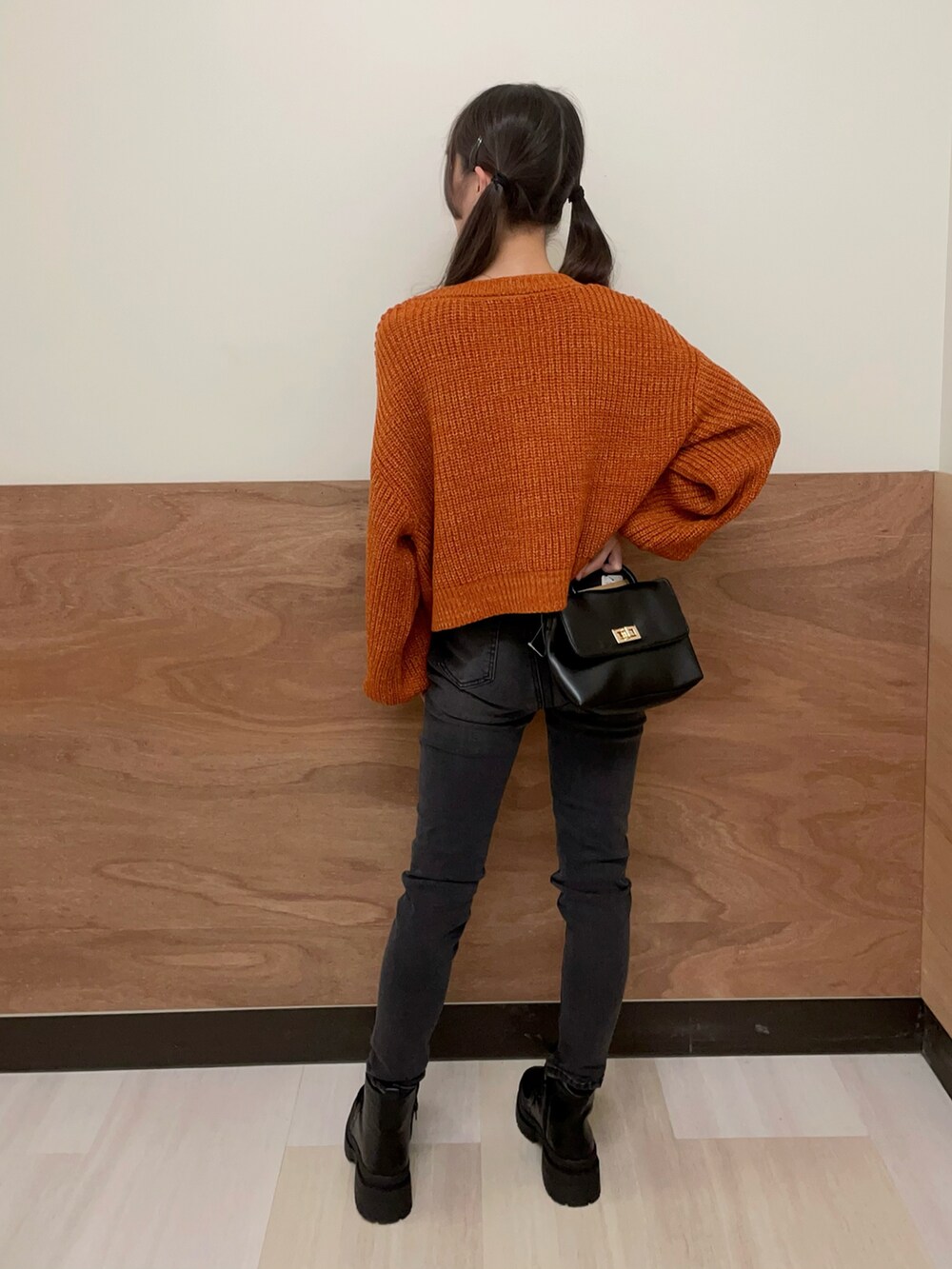 ブラック系のショルダーバッグ、ブラック系のブーツ、ブラック系のデニムパンツを着用したレディースの秋コーディネートの4枚目の写真