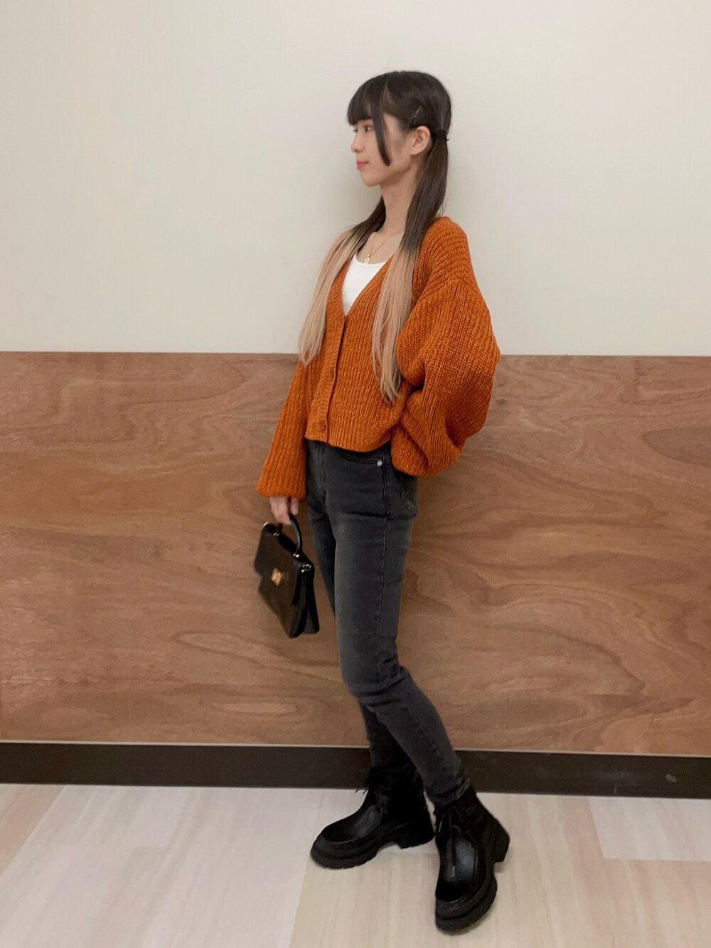 ブラック系のショルダーバッグ、ブラック系のブーツ、ブラック系のデニムパンツを着用したレディースの秋コーディネートの3枚目の写真