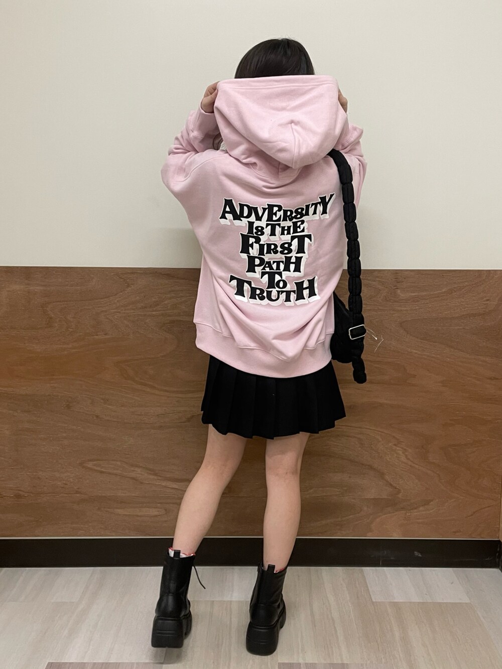 ブラック系のブーツ、ブラック系のスカート、ブラック系のショルダーバッグを着用したレディースの冬コーディネートの3枚目の写真