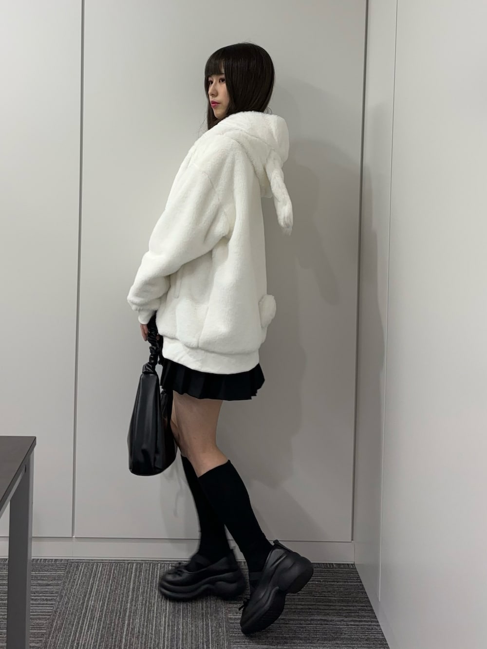 ブラック系のドレスシューズ、ブラック系のショルダーバッグ、ブラック系のスカートを着用したレディースの秋コーディネートの3枚目の写真