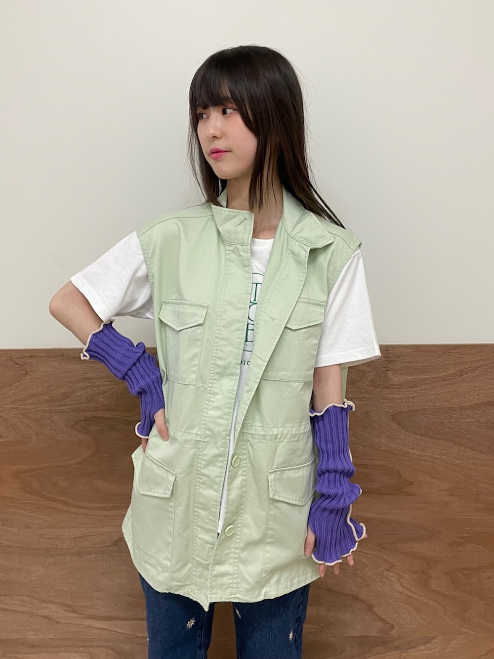 ブルー系のデニムパンツ、ホワイト系のTシャツ/カットソー、グリーン系のベストを着用したレディースの春コーディネートの3枚目の写真