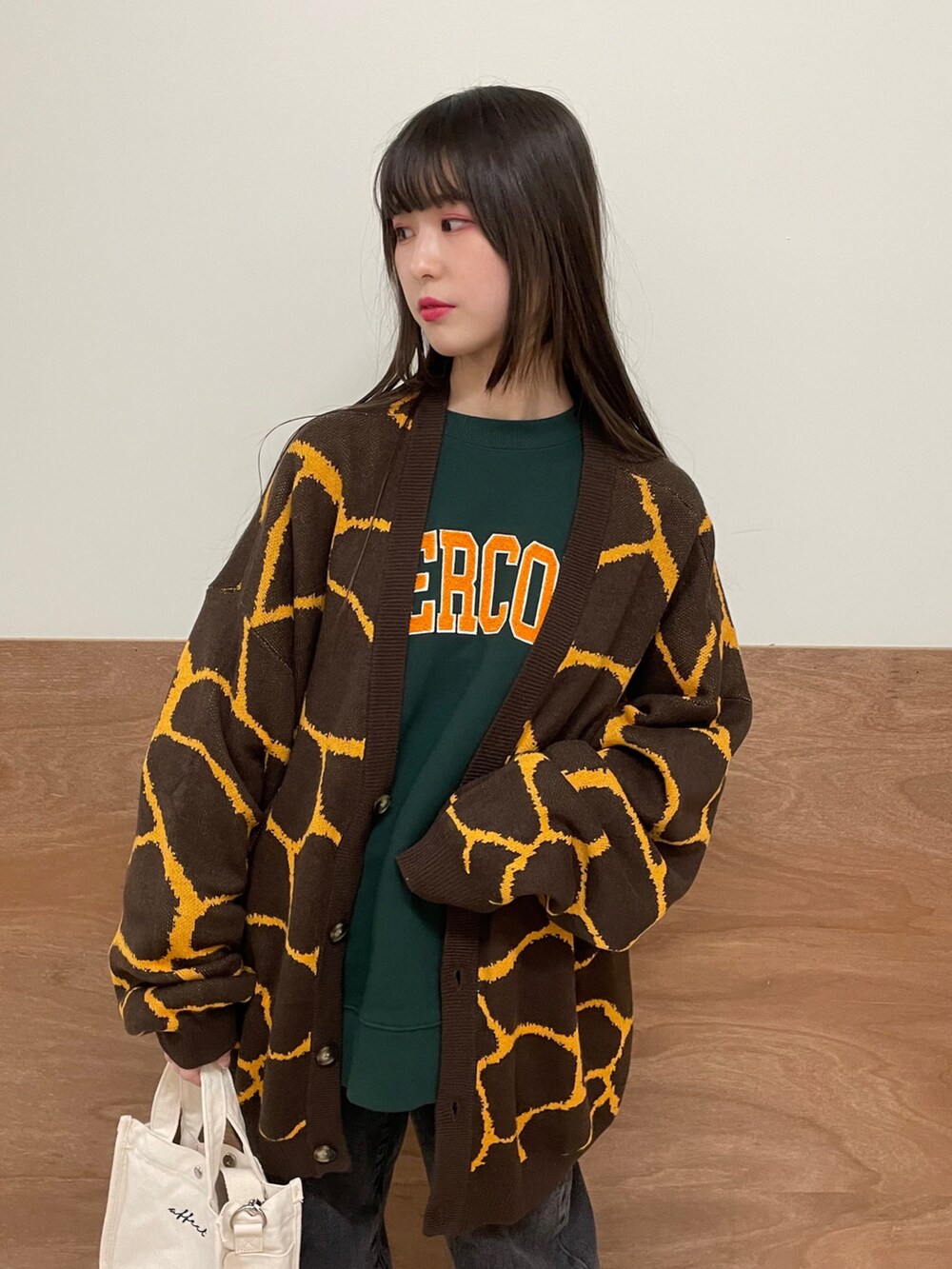 ブラック系のデニムパンツ、その他のショルダーバッグ、グリーン系のスウェットを着用したレディースの春コーディネートの4枚目の写真