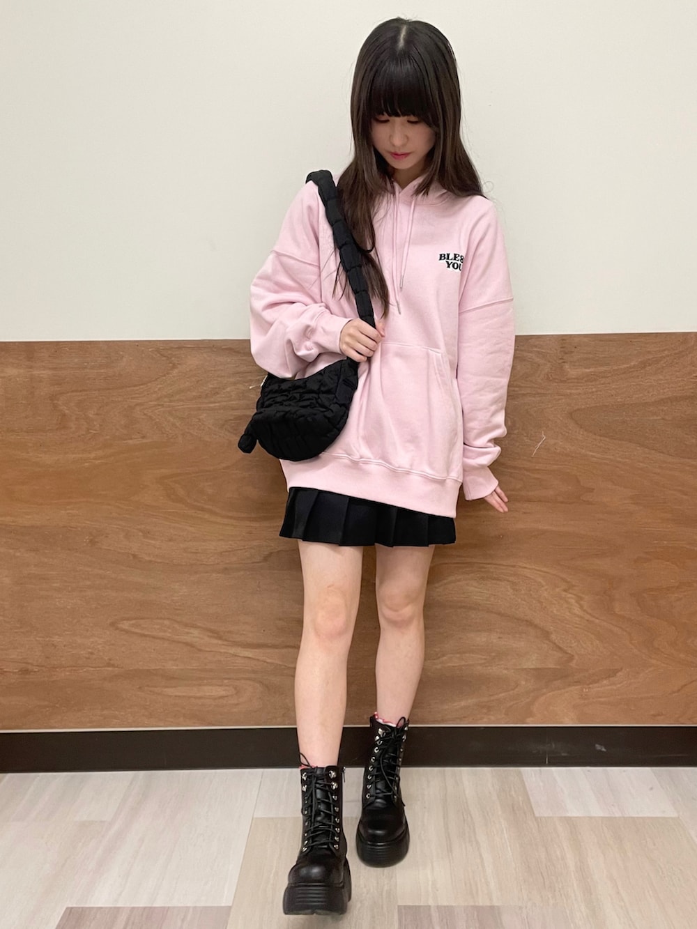 ブラック系のブーツ、ブラック系のスカート、ブラック系のショルダーバッグを着用したレディースの冬コーディネートの2枚目の写真