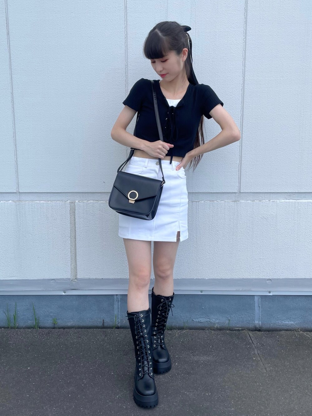 ブラック系のTシャツ/カットソー、ホワイト系のスカート、ブラック系のブーツを着用したレディースの夏コーディネートの3枚目の写真