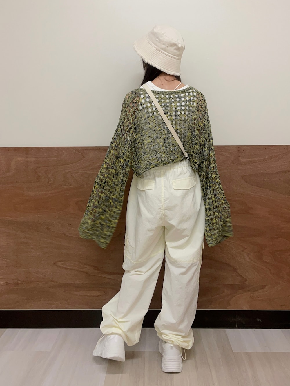 ホワイト系のスニーカー、ホワイト系のカーゴパンツ、ホワイト系のショルダーバッグを着用したレディースの夏コーディネートの4枚目の写真