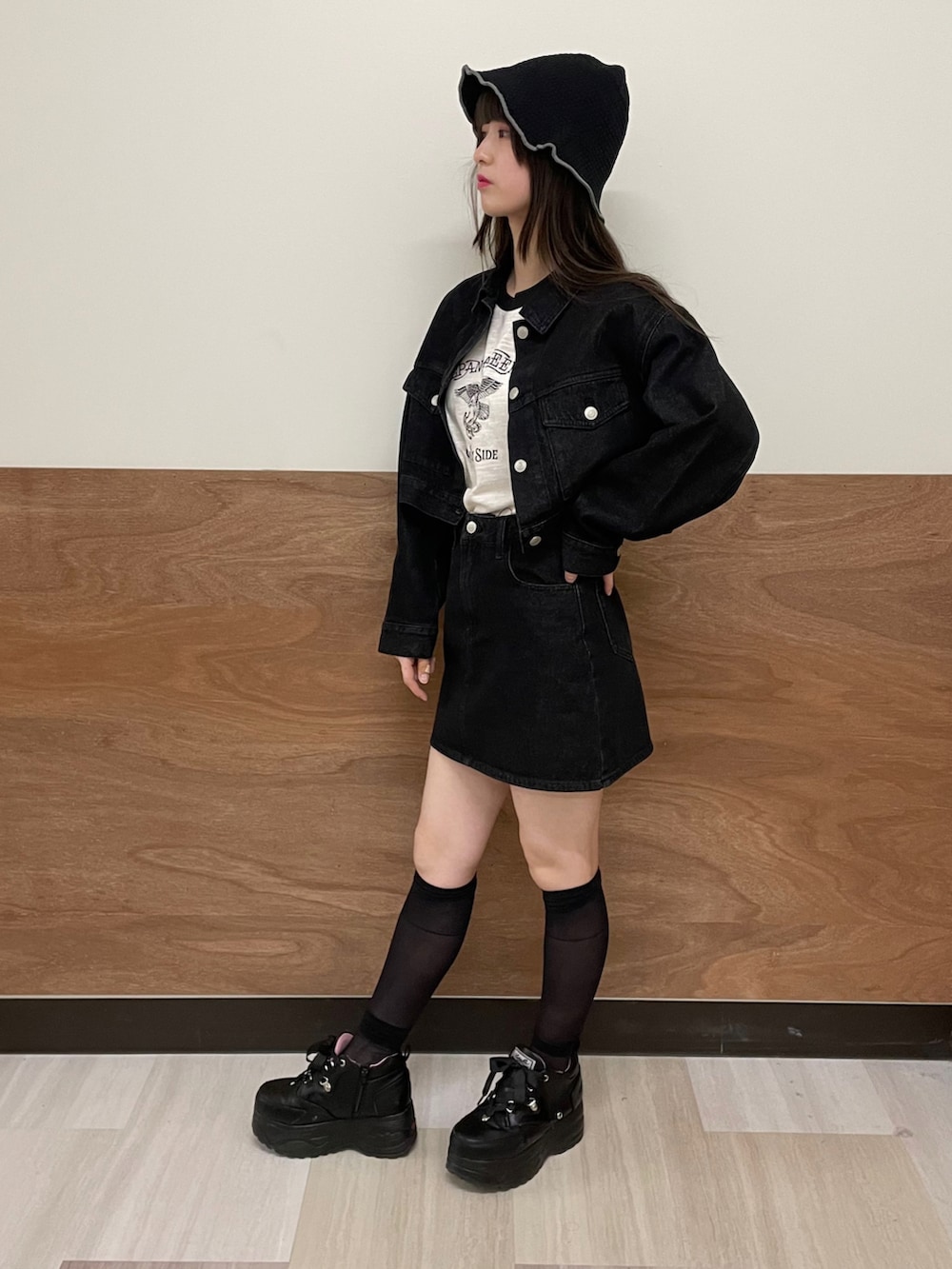 ブラック系のデニムスカート、ブラック系のデニムジャケット、ホワイト系のTシャツ/カットソーを着用したレディースの春コーディネートの3枚目の写真