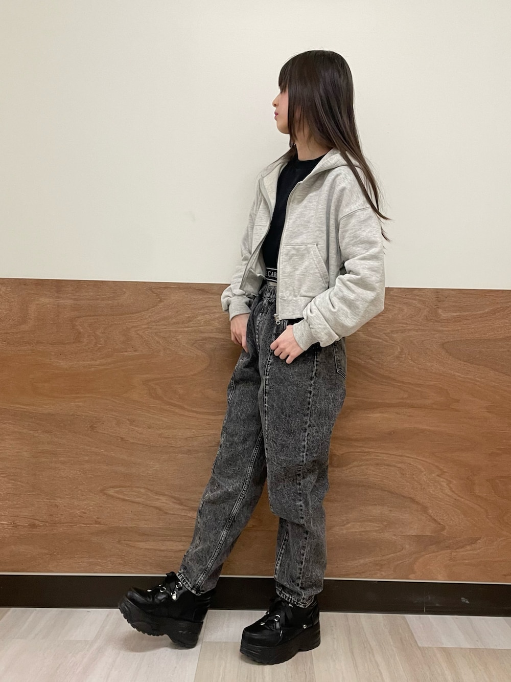 グレー系のパーカー、ブラック系のスウェット、ブラック系のデニムパンツを着用したレディースの冬コーディネートの3枚目の写真