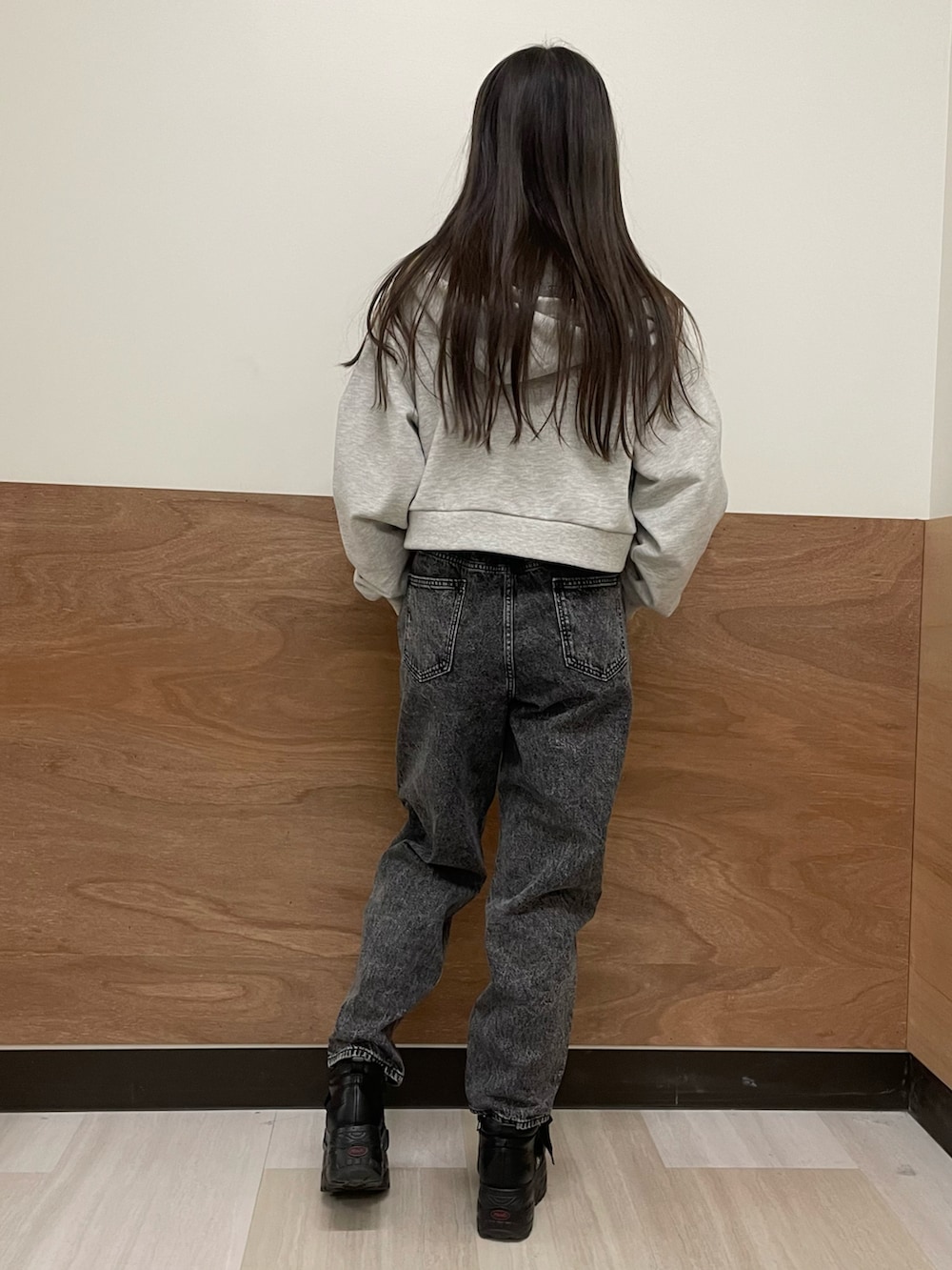 グレー系のパーカー、ブラック系のスウェット、ブラック系のデニムパンツを着用したレディースの冬コーディネートの4枚目の写真