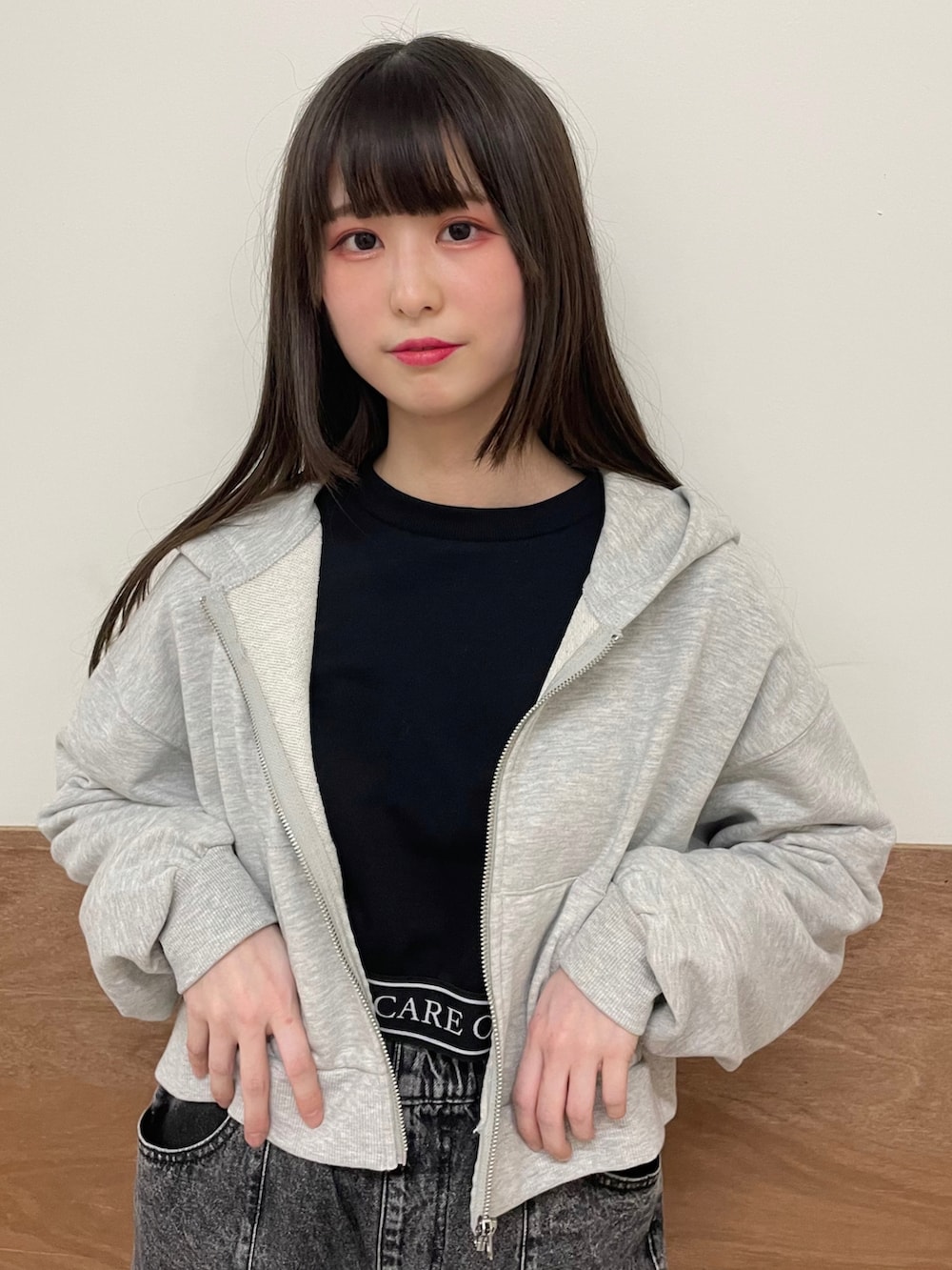 グレー系のパーカー、ブラック系のスウェット、ブラック系のデニムパンツを着用したレディースの冬コーディネートの5枚目の写真