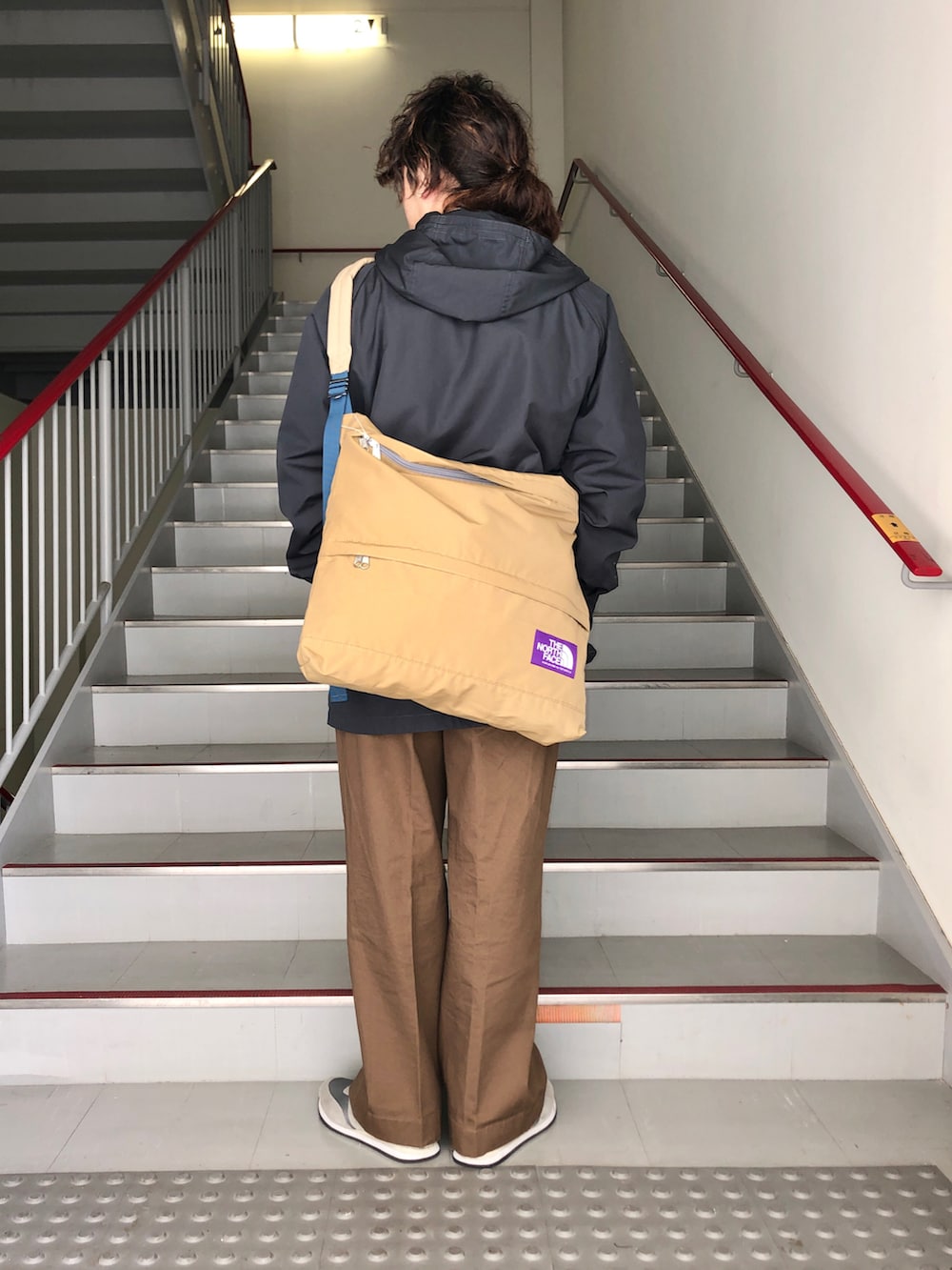 ブラウン系のその他パンツ、グレー系のスニーカー、ブラック系のマウンテンパーカーを着用したメンズの春コーディネートの3枚目の写真