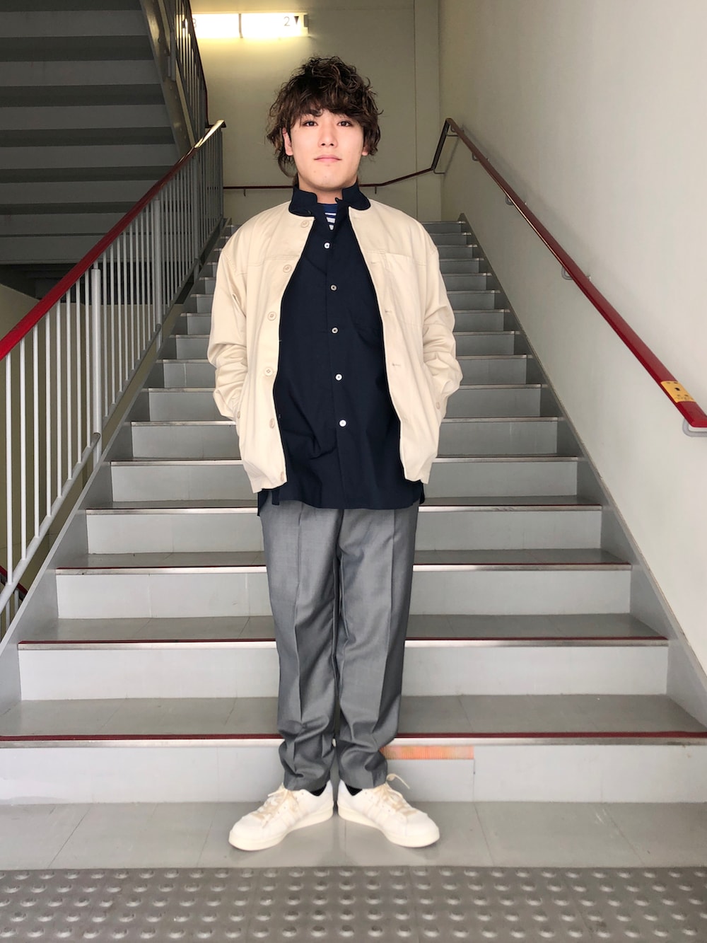 グレー系のスラックス、ベージュ系のブルゾン、ブルー系のシャツ/ブラウスを着用したメンズの春コーディネートの2枚目の写真