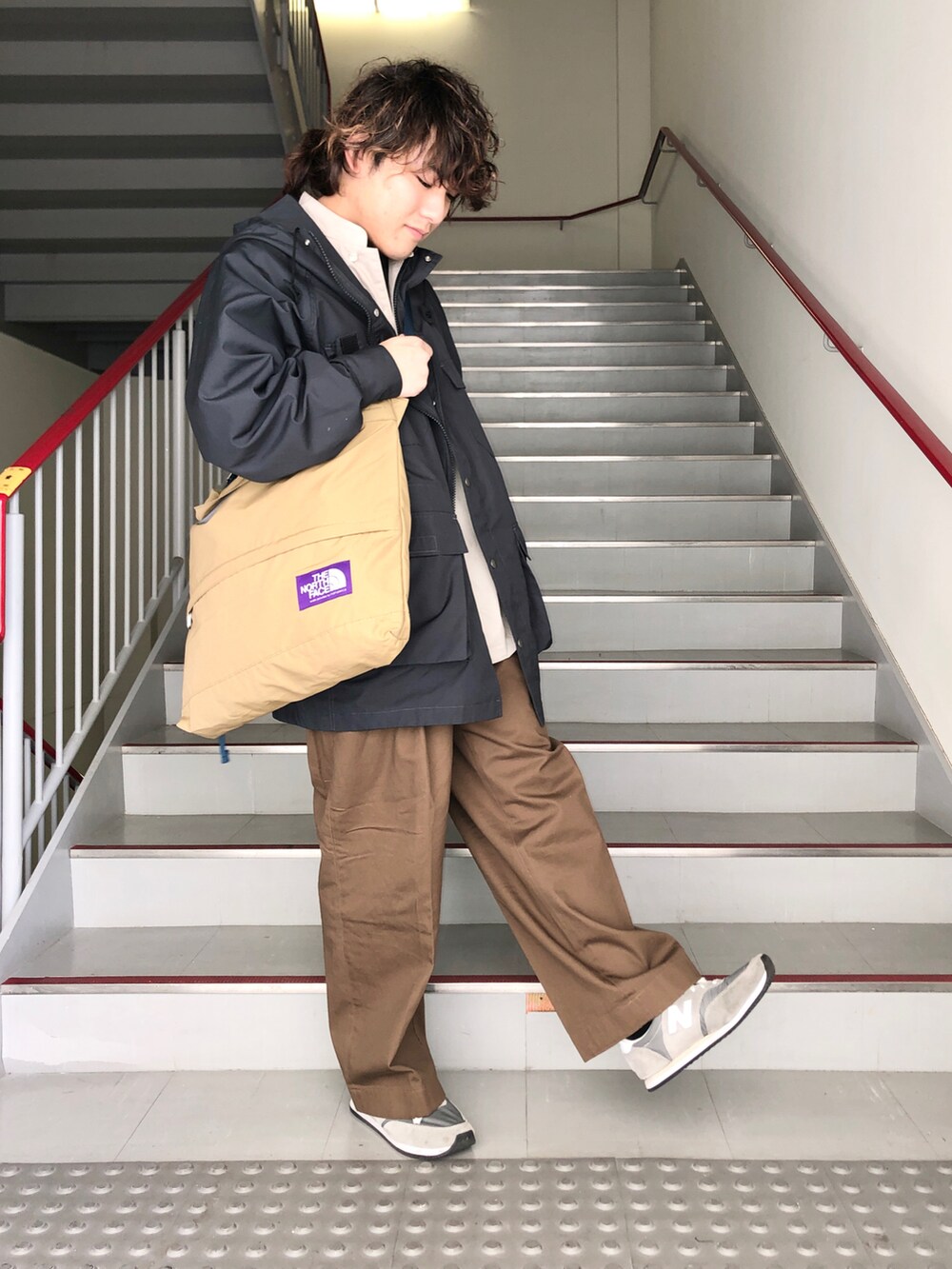 ブラウン系のその他パンツ、グレー系のスニーカー、ブラック系のマウンテンパーカーを着用したメンズの春コーディネートの2枚目の写真