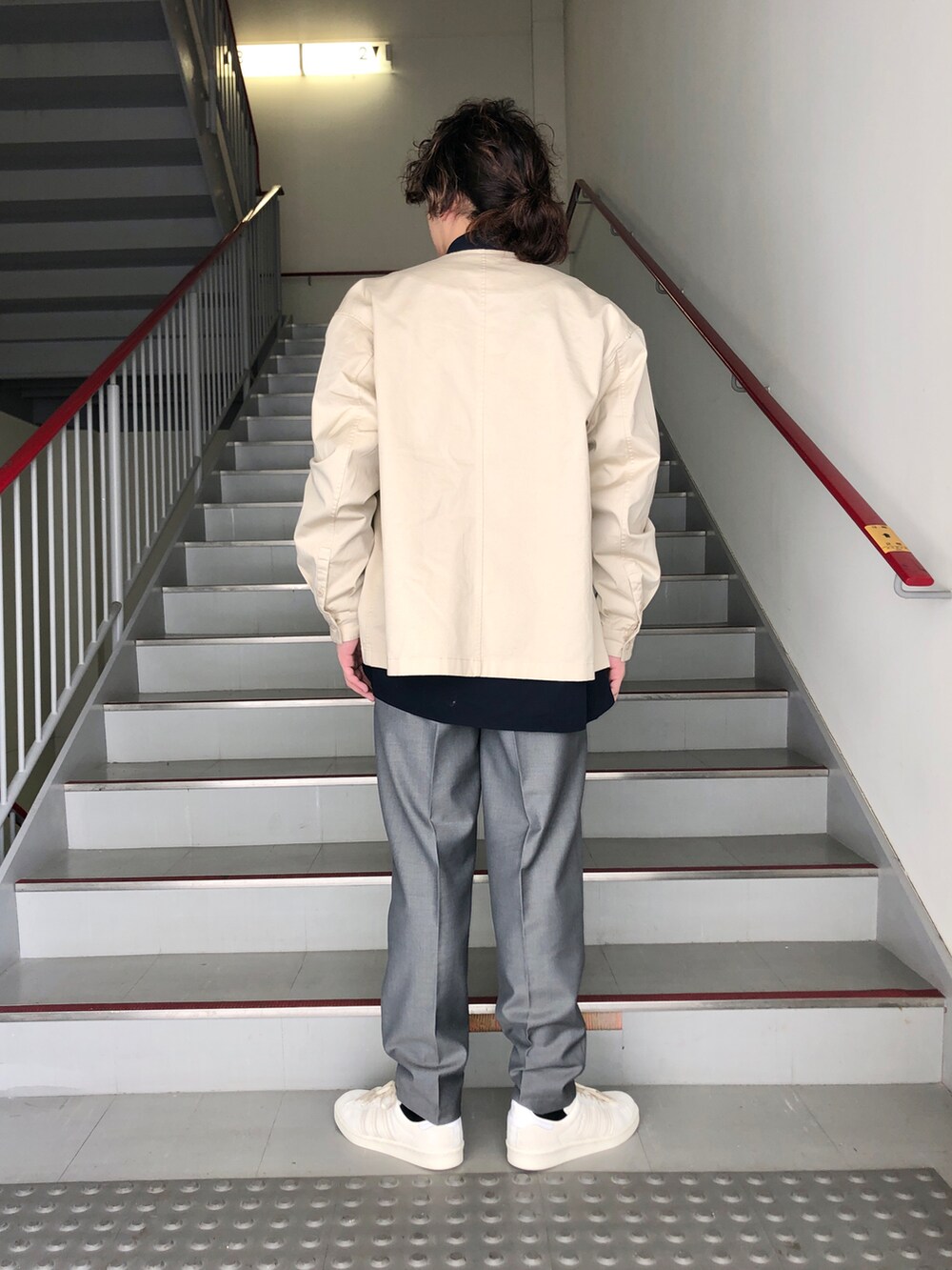 グレー系のスラックス、ベージュ系のブルゾン、ブルー系のシャツ/ブラウスを着用したメンズの春コーディネートの4枚目の写真