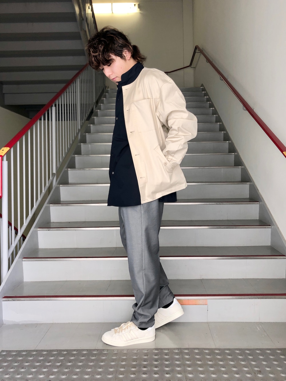 グレー系のスラックス、ベージュ系のブルゾン、ブルー系のシャツ/ブラウスを着用したメンズの春コーディネートの3枚目の写真