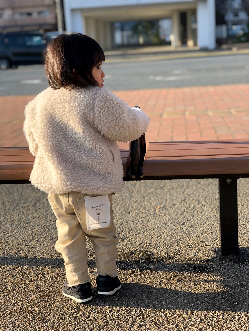 ベージュ系のデニムパンツ、ブラック系のスニーカー、ホワイト系のTシャツ/カットソーを着用したキッズの冬コーディネートの2枚目の写真