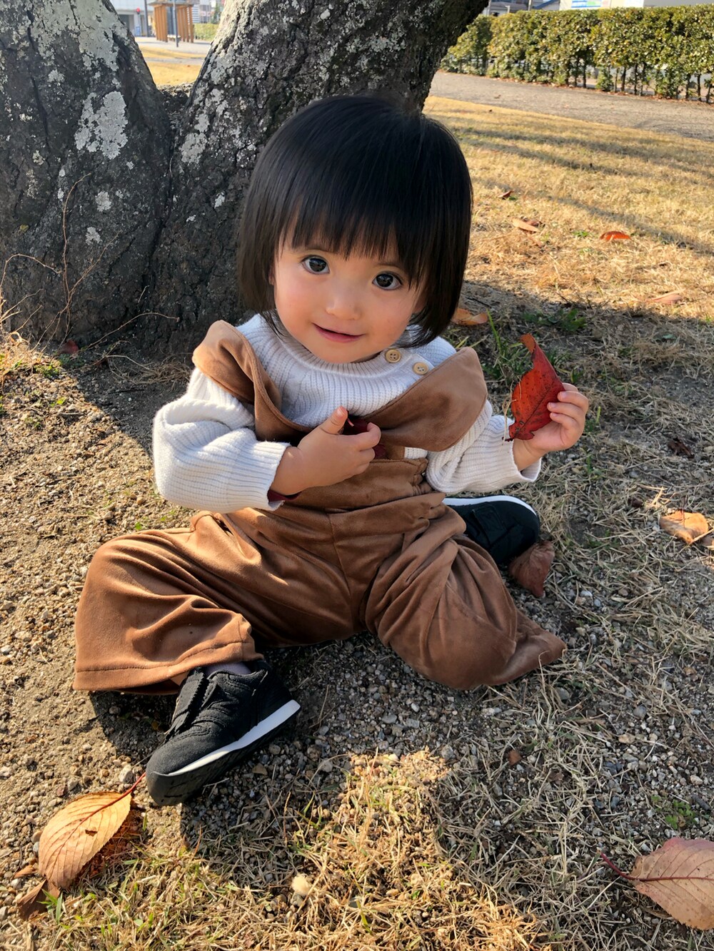 ブラウン系のパンツ、ブラック系のスニーカーを着用したキッズの冬コーディネートの2枚目の写真