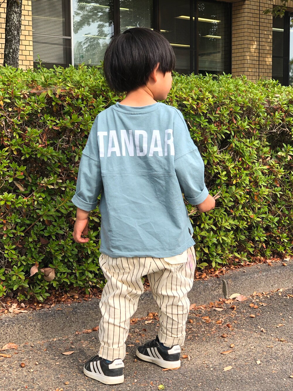 その他のチノパンツ、ブラック系のスニーカー、ブルー系のTシャツ/カットソーを着用したキッズの秋コーディネートの2枚目の写真