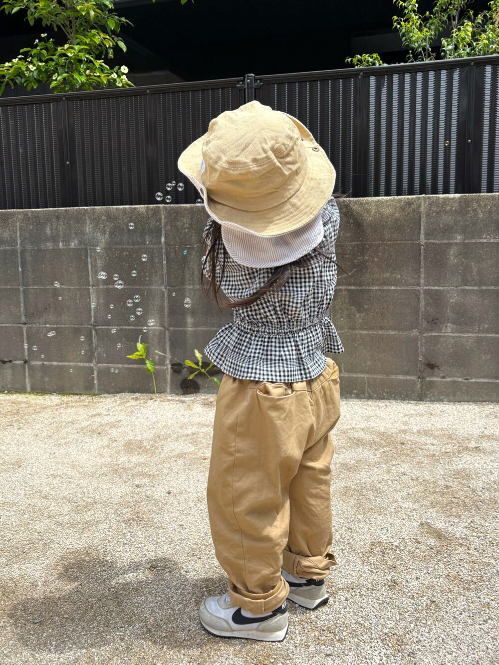 ベージュ系のその他パンツ、ホワイト系のスニーカー、ブラック系のシャツ/ブラウスを着用したキッズの春コーディネートの4枚目の写真