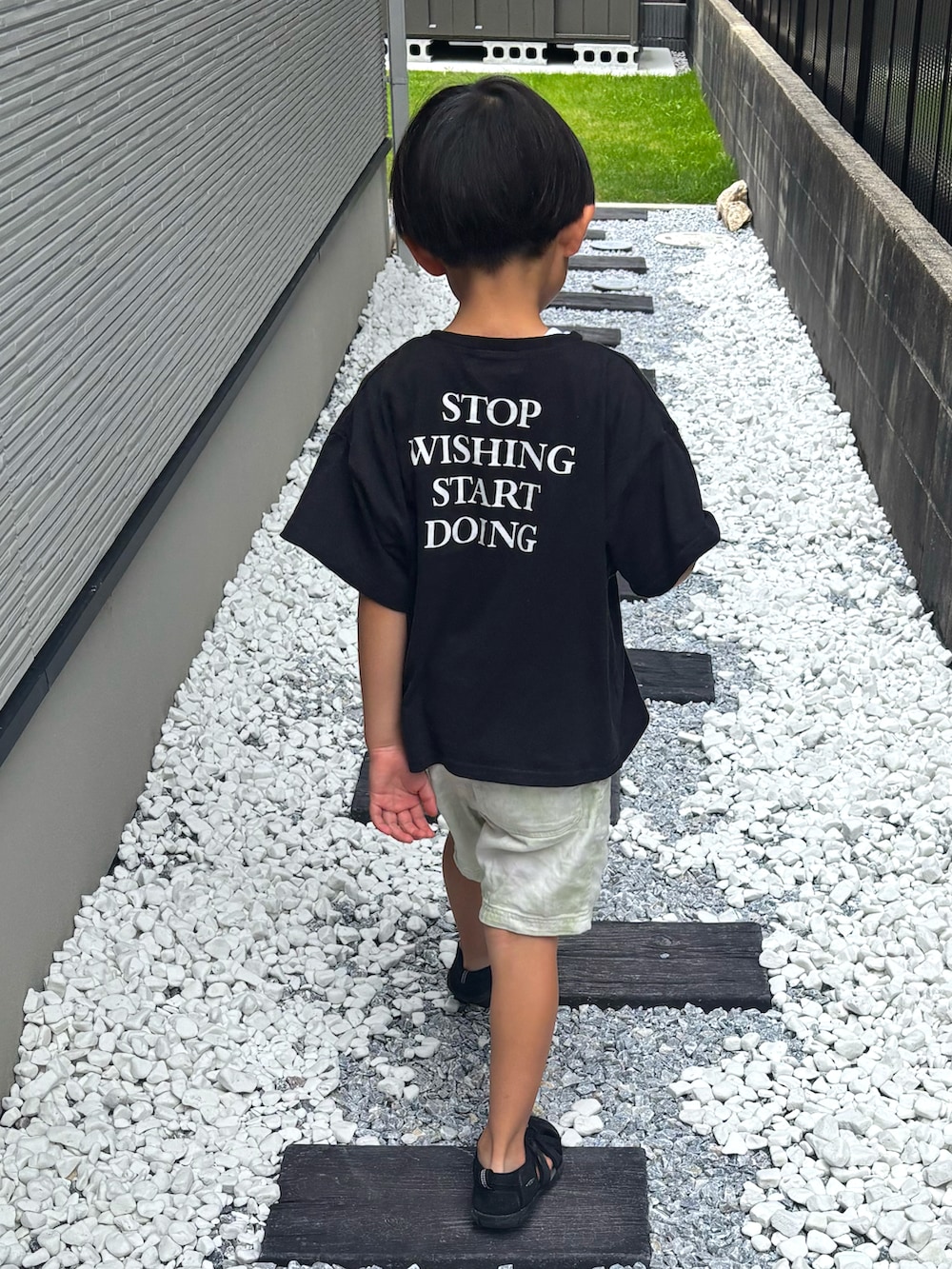 ブラック系のTシャツ/カットソー、グリーン系のその他パンツ、ブラック系のサンダルを着用したキッズの夏コーディネートの2枚目の写真