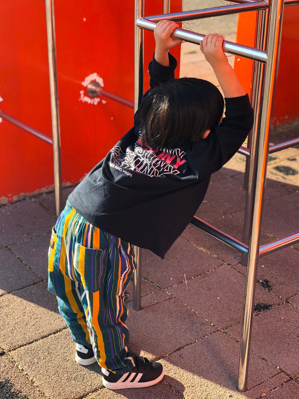 グリーン系のその他パンツ、ブラック系のスニーカー、ブラック系のTシャツ/カットソーを着用したキッズの冬コーディネートの3枚目の写真