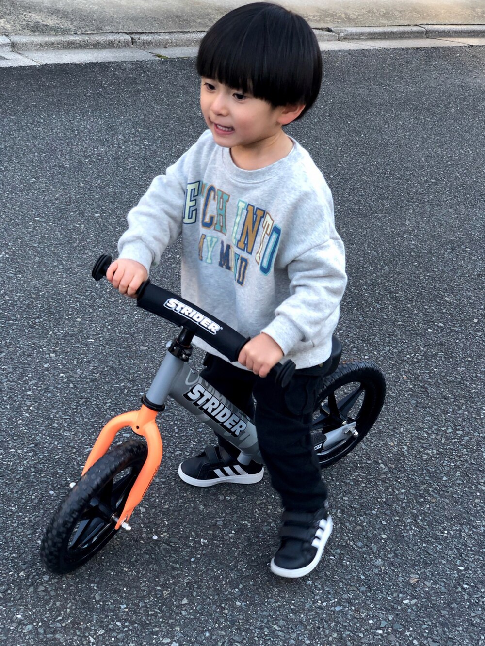 グレー系のスウェット、ブラック系のカーゴパンツ、ブラック系のスニーカーを着用したキッズの冬コーディネートの2枚目の写真