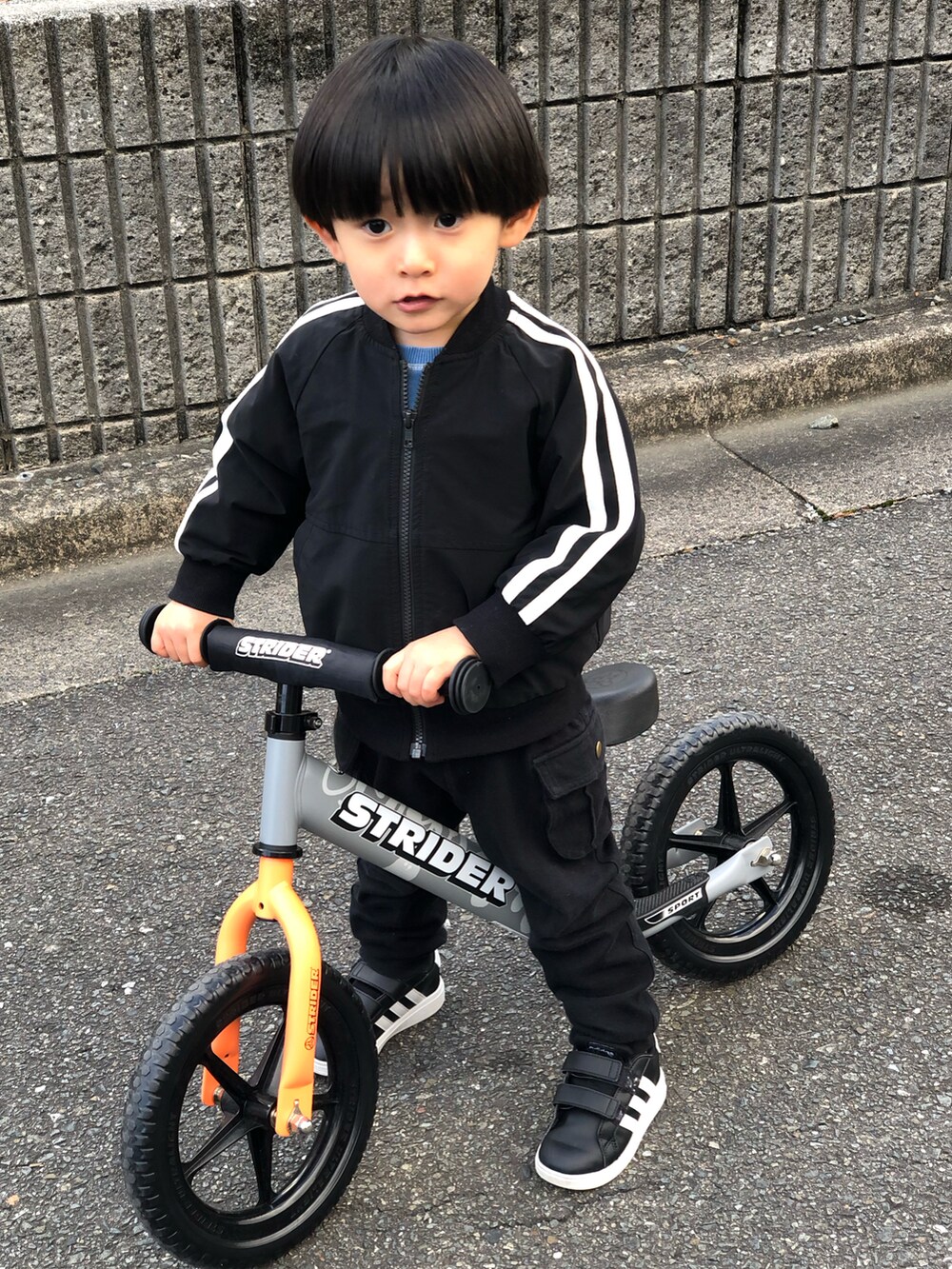 ブラック系のブルゾン、ブラック系のカーゴパンツ、ブラック系のスニーカーを着用したキッズの冬コーディネートの2枚目の写真