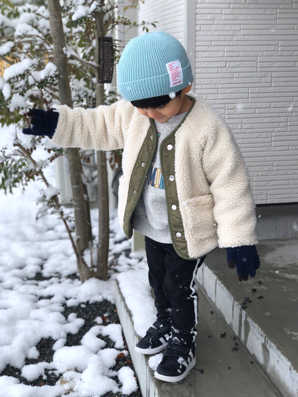 ホワイト系のダウンジャケット/コート、グレー系のスウェット、ブラック系のパンツを着用したキッズの冬コーディネートの4枚目の写真