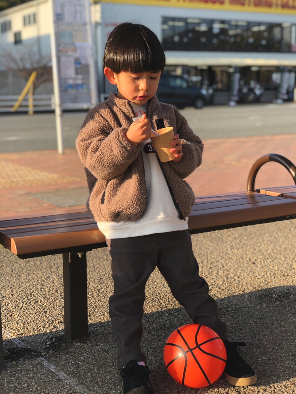 ホワイト系のスウェット、ブラウン系のブルゾン、ブラック系のスニーカーを着用したキッズの冬コーディネートの2枚目の写真