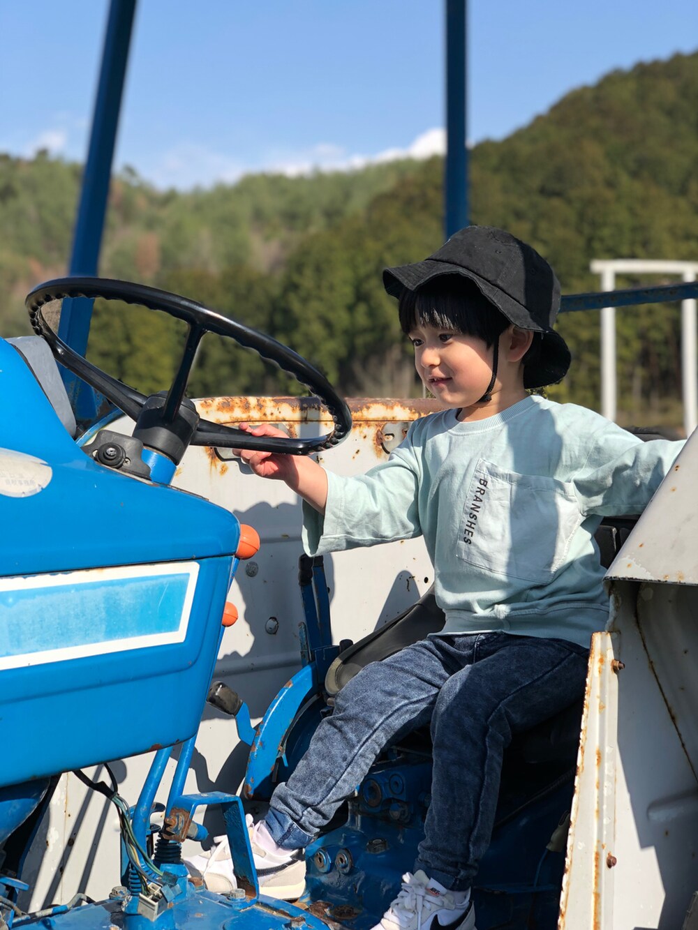 ホワイト系のスニーカー、グリーン系のTシャツ/カットソー、ブルー系のデニムパンツを着用したキッズの春コーディネートの2枚目の写真