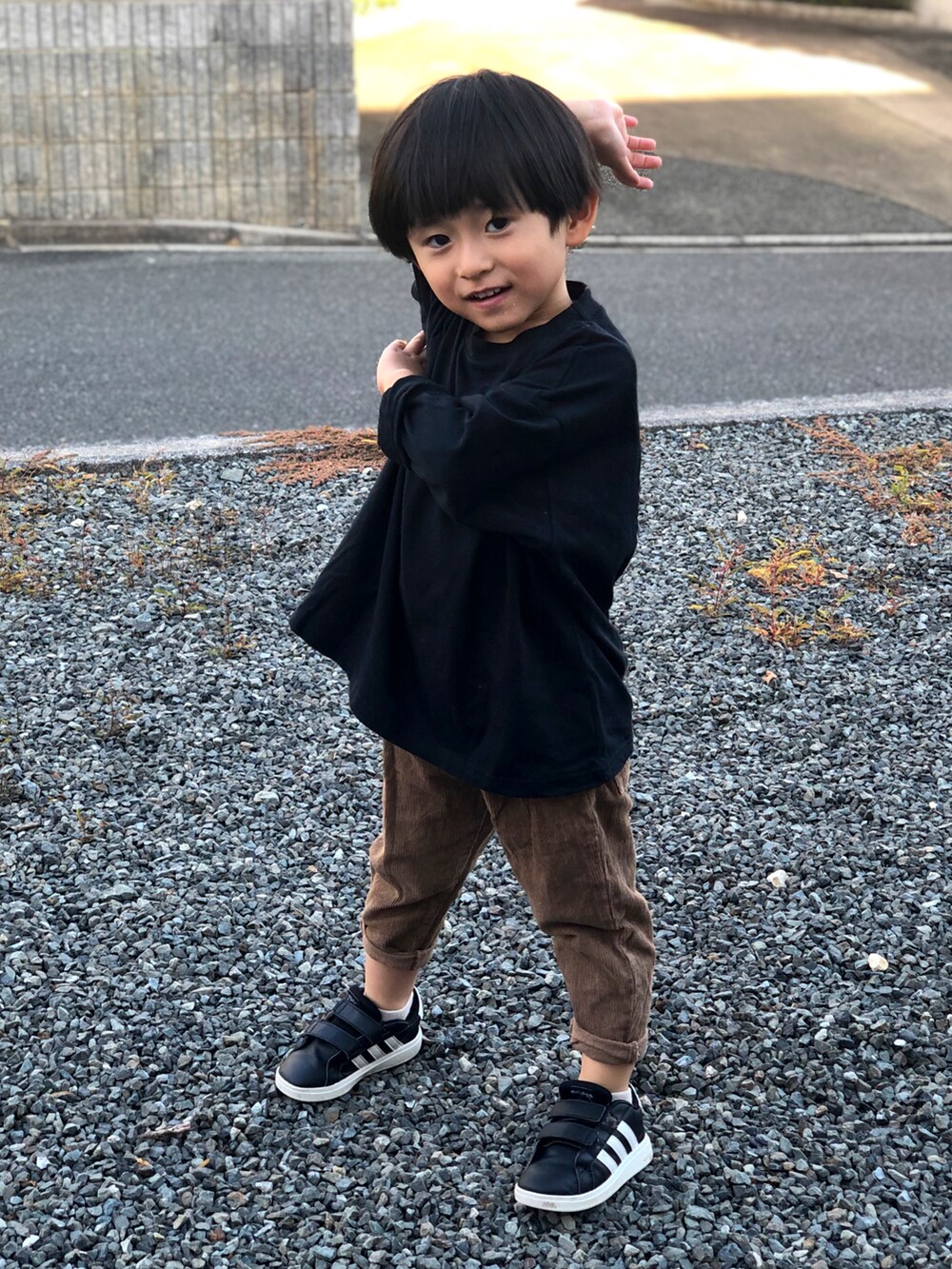 ブラック系のスニーカー、ブラウン系のその他パンツ、ブラック系のTシャツ/カットソーを着用したキッズの秋コーディネートの2枚目の写真