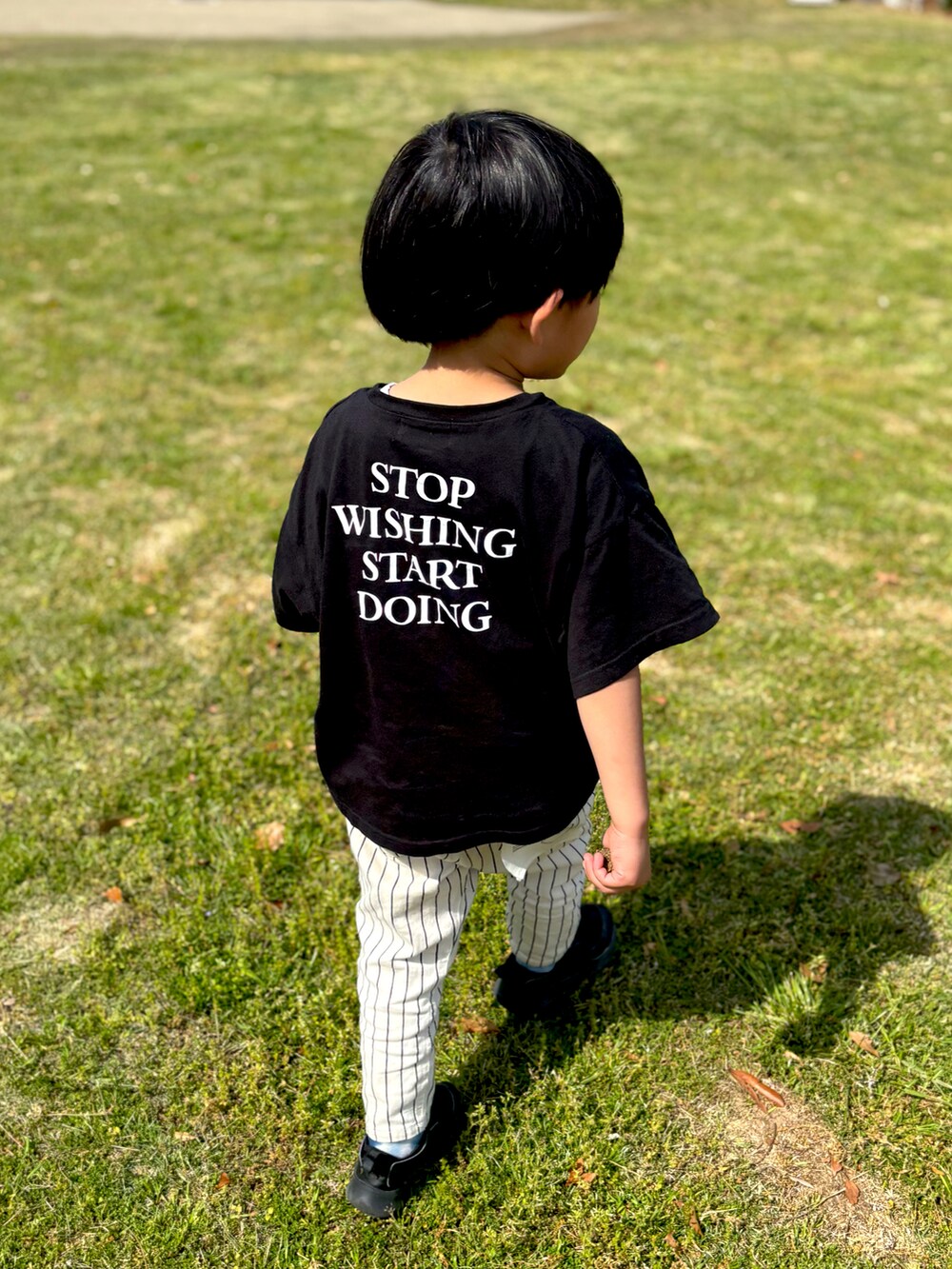 ブラック系のTシャツ/カットソー、その他のチノパンツ、ブラック系のスニーカーを着用したキッズの春コーディネートの2枚目の写真