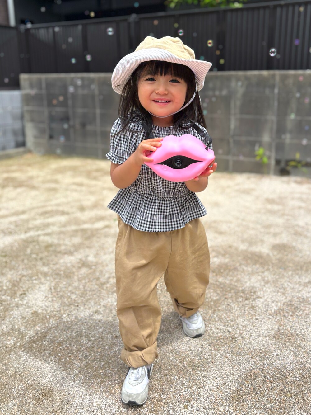ベージュ系のその他パンツ、ホワイト系のスニーカー、ブラック系のシャツ/ブラウスを着用したキッズの春コーディネートの2枚目の写真