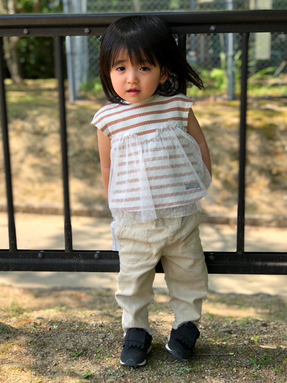 ブラウン系のTシャツ/カットソー、ベージュ系のデニムパンツ、ブラック系のスニーカーを着用したキッズの春コーディネートの2枚目の写真