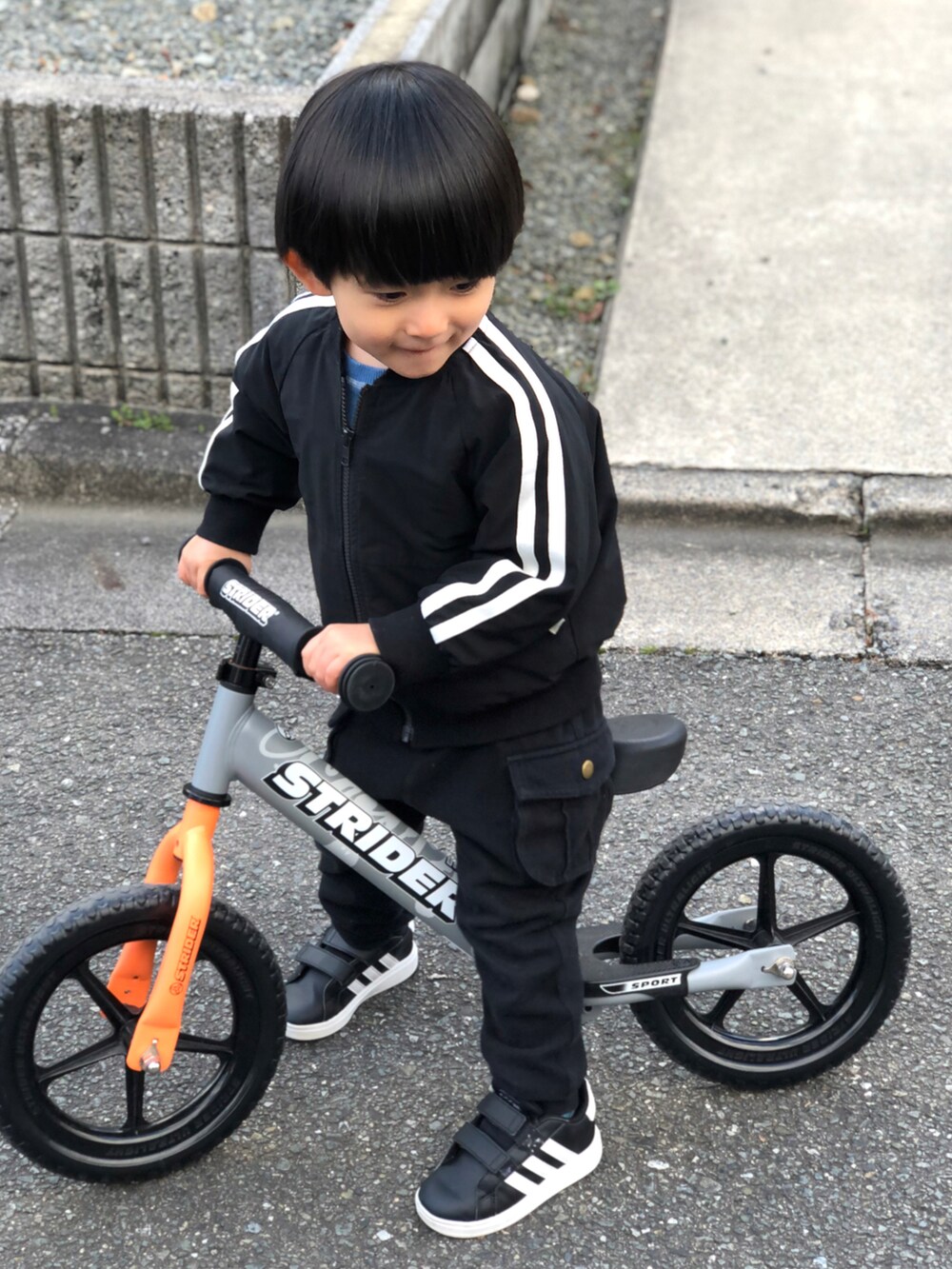 ブラック系のブルゾン、ブラック系のカーゴパンツ、ブラック系のスニーカーを着用したキッズの冬コーディネートの3枚目の写真