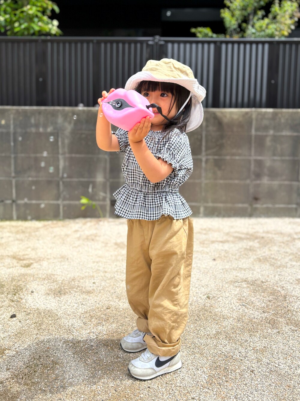 ベージュ系のその他パンツ、ホワイト系のスニーカー、ブラック系のシャツ/ブラウスを着用したキッズの春コーディネートの3枚目の写真