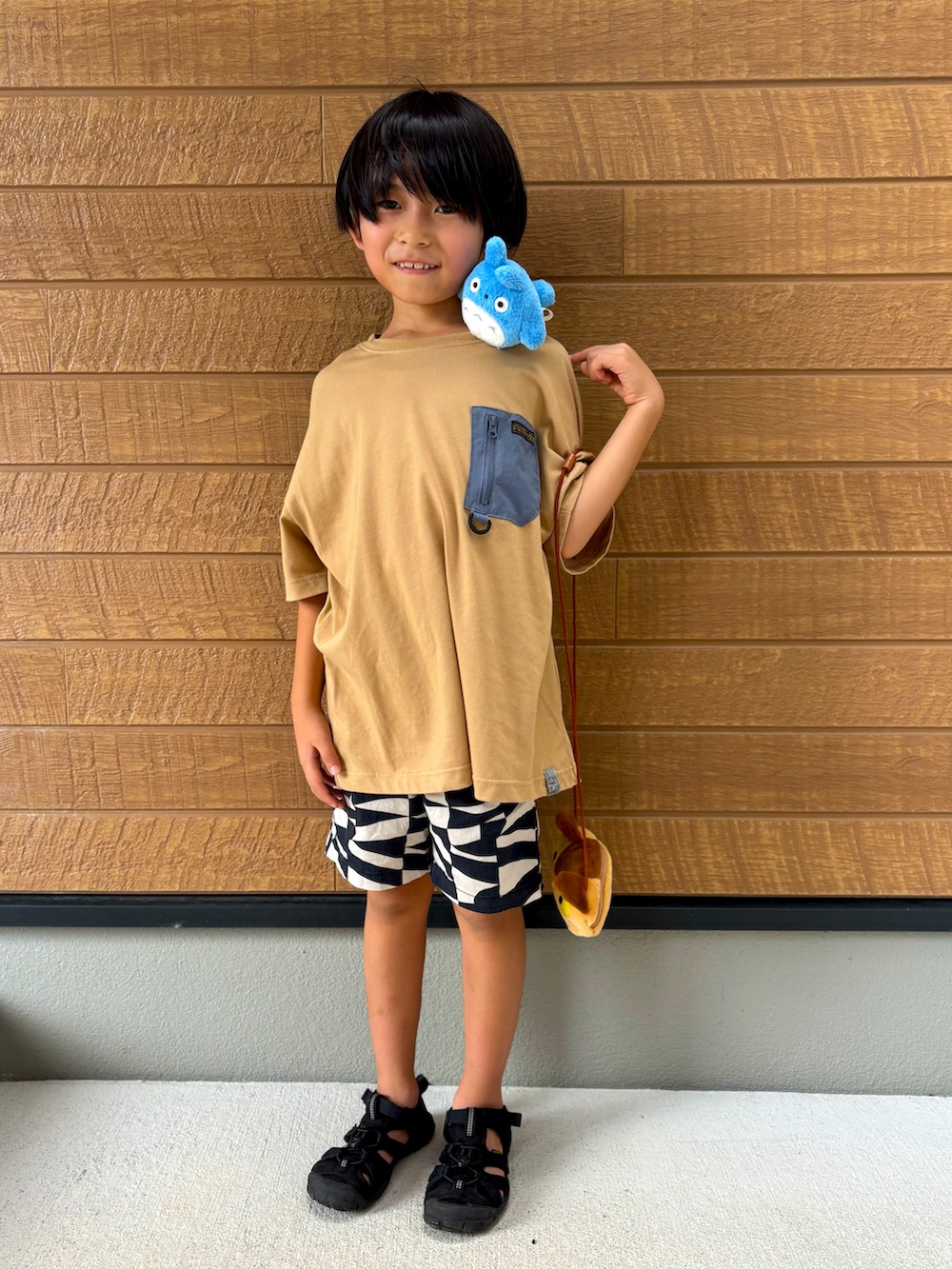 ブラック系のその他パンツ、ブラック系のサンダル、ベージュ系のTシャツ/カットソーを着用したキッズの夏コーディネートの3枚目の写真