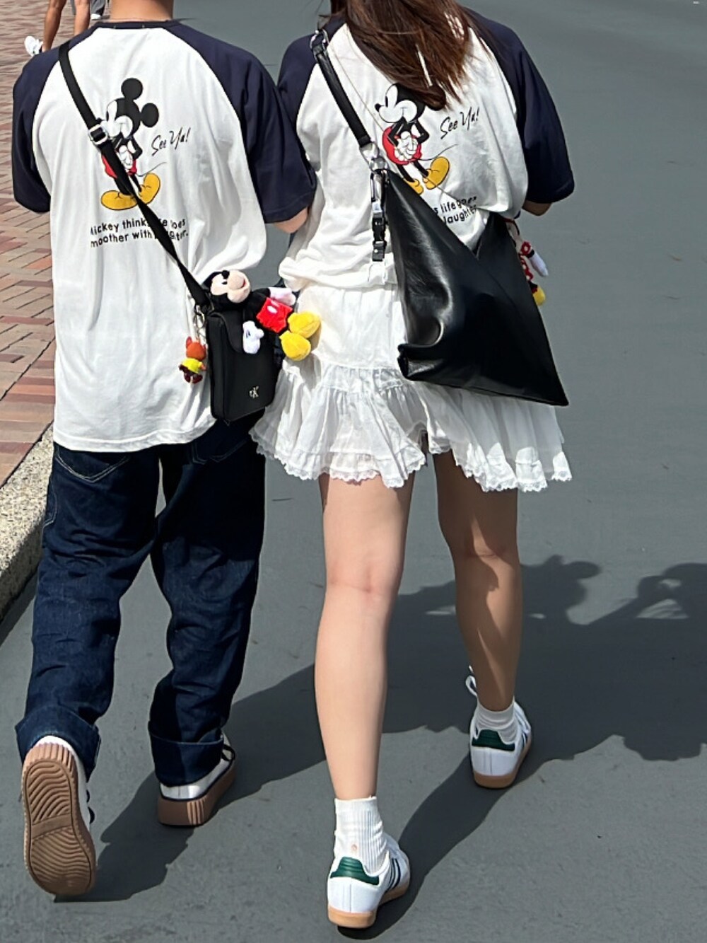 ホワイト系のTシャツ/カットソー、ホワイト系のスカート、ホワイト系のスニーカーを着用したレディースの秋コーディネートの2枚目の写真