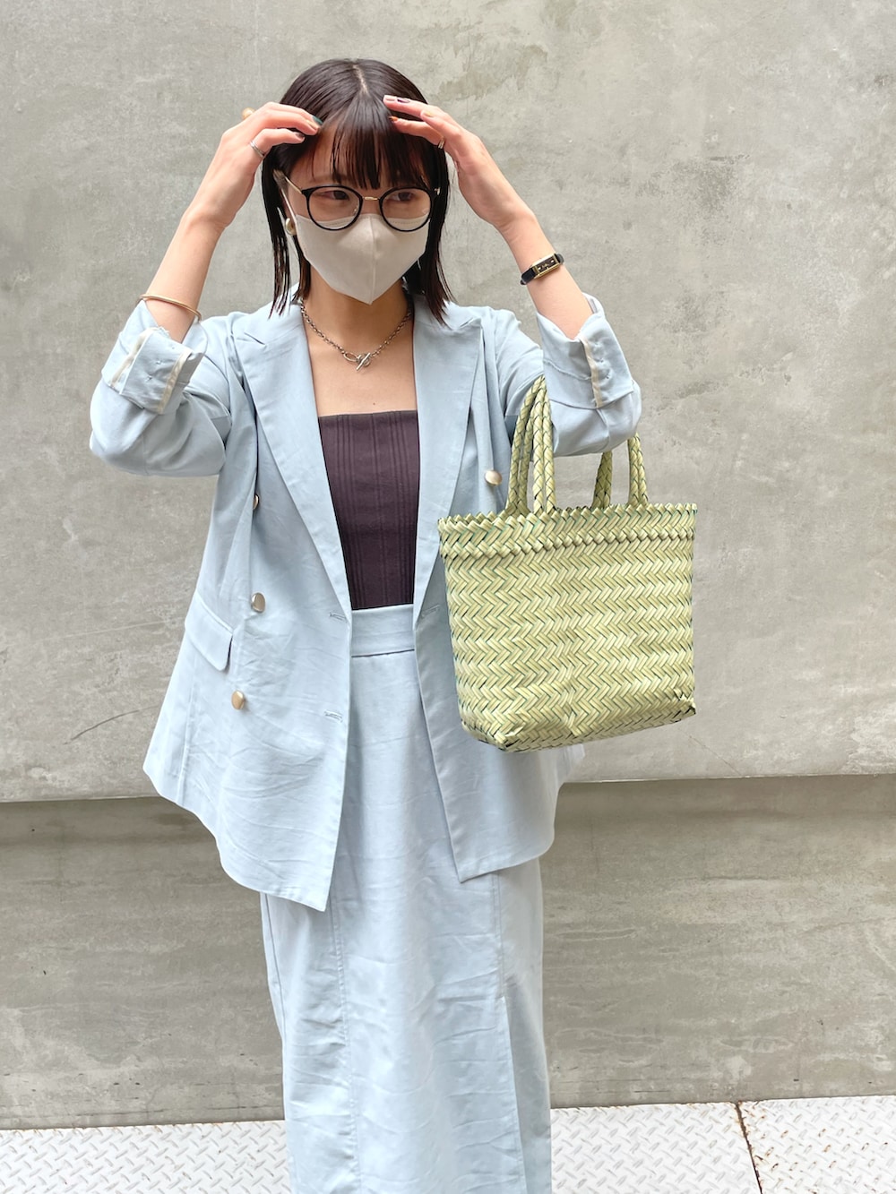 ブルー系のテーラードジャケット、ブルー系のスカート、グリーン系のバッグを着用したレディースの春コーディネートの4枚目の写真