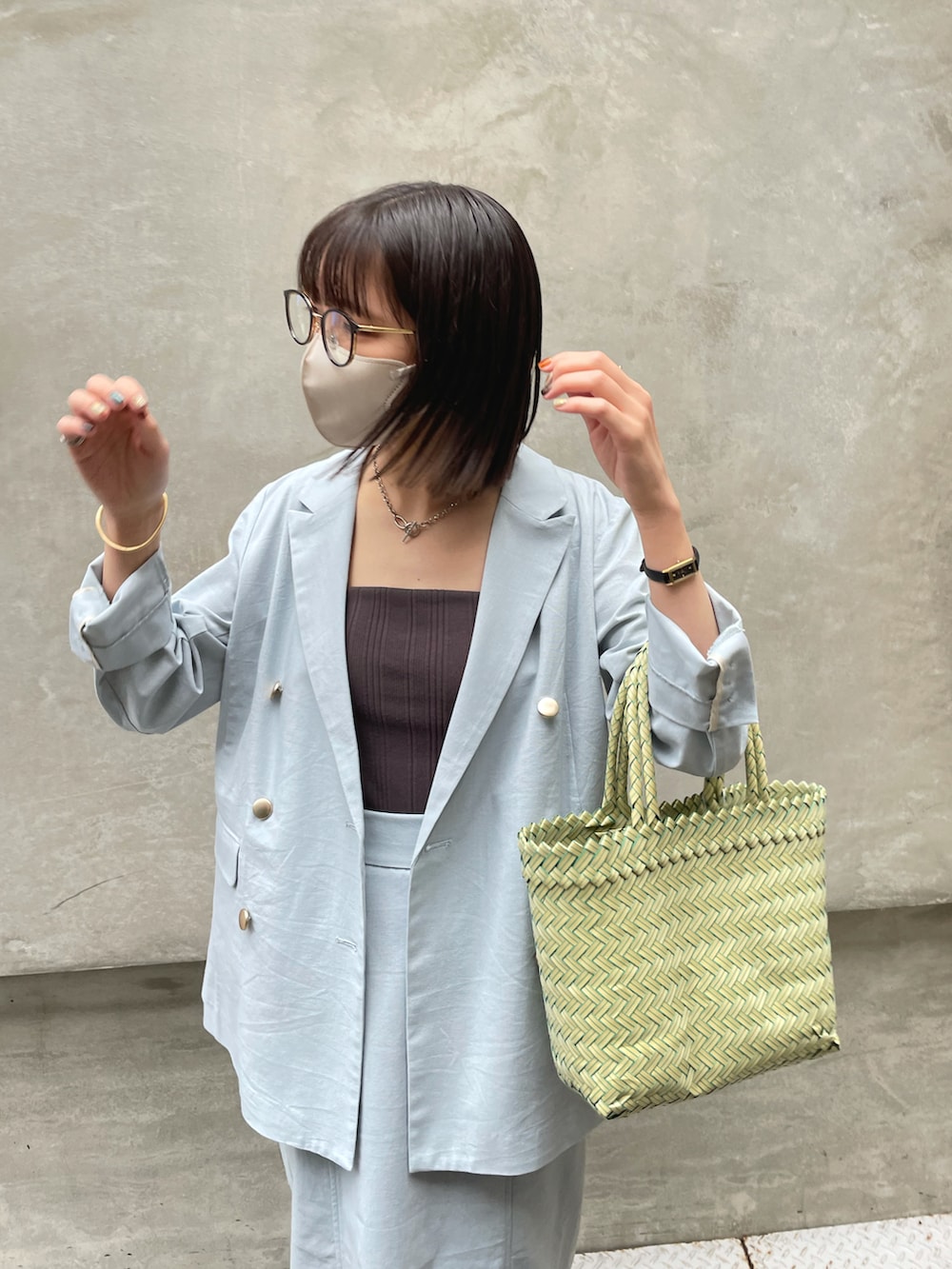 ブルー系のテーラードジャケット、ブルー系のスカート、グリーン系のバッグを着用したレディースの春コーディネートの5枚目の写真