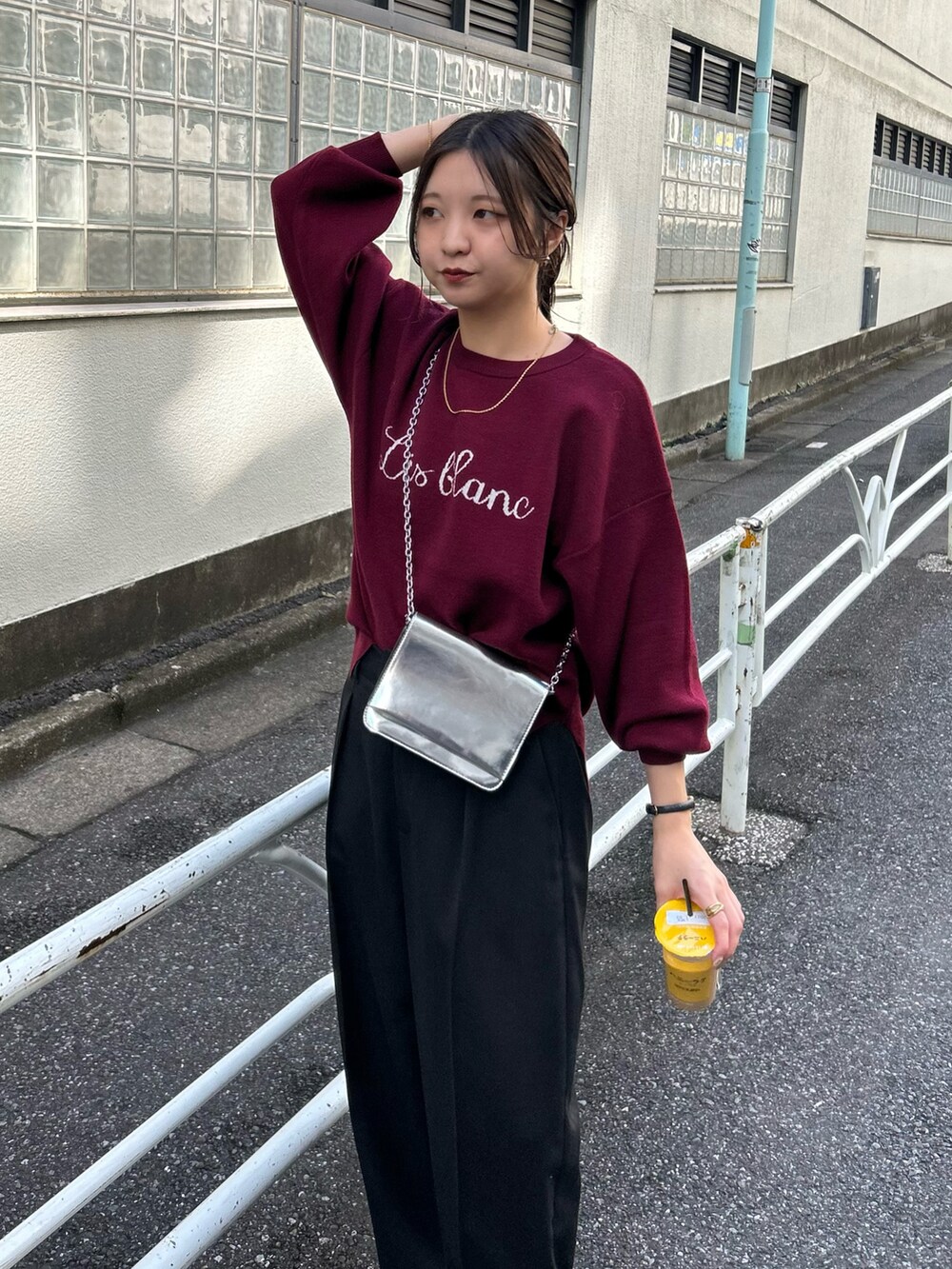 ブラック系のパンツ、シルバー系のショルダーバッグ、レッド系のニット/セーターを着用したレディースの秋コーディネートの2枚目の写真