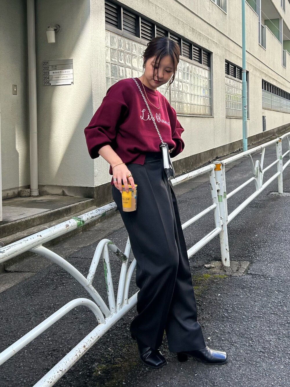 ブラック系のパンツ、シルバー系のショルダーバッグ、レッド系のニット/セーターを着用したレディースの秋コーディネートの3枚目の写真