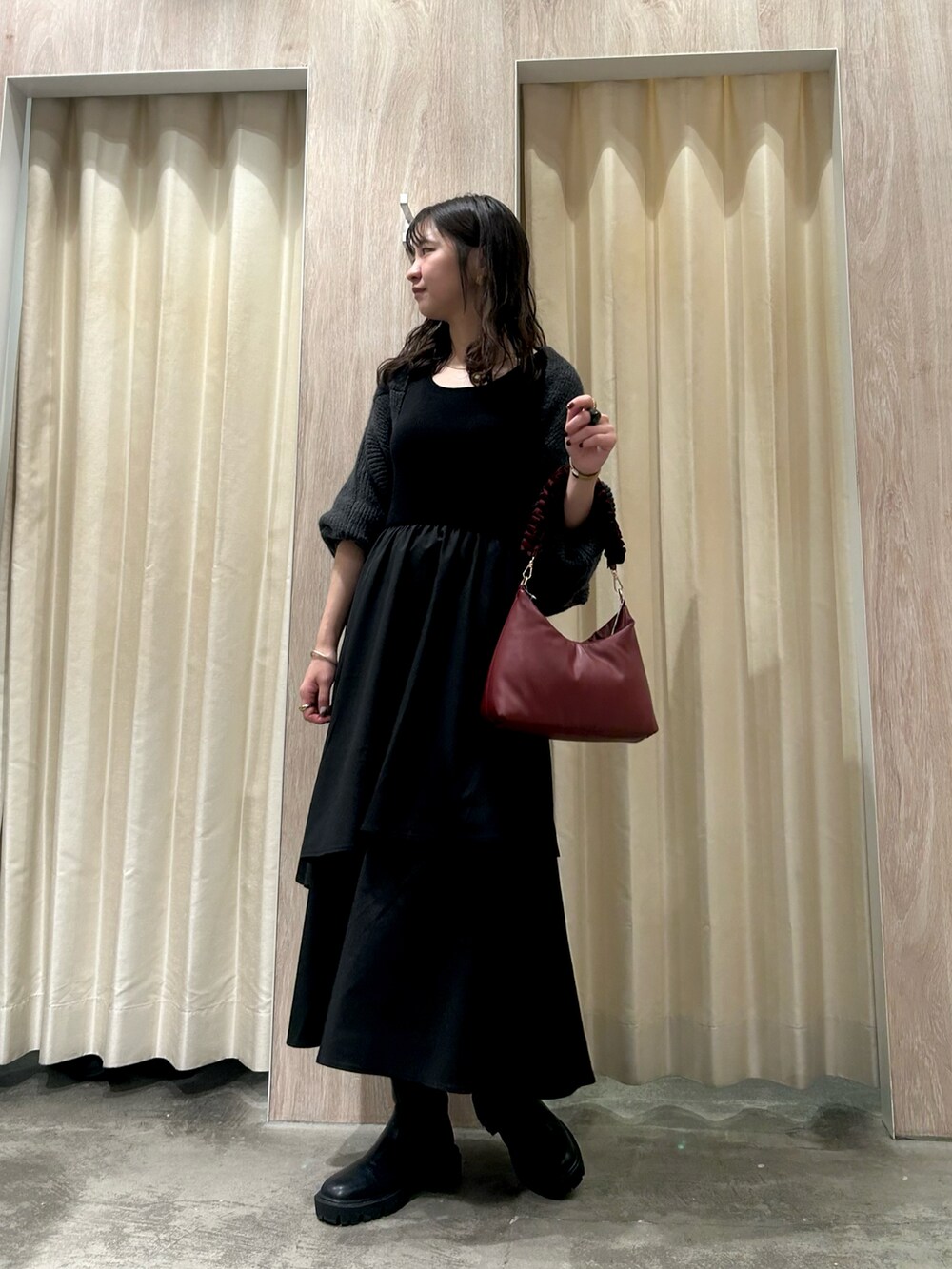 グレー系のワンピース、レッド系のショルダーバッグを着用したレディースの秋コーディネートの2枚目の写真