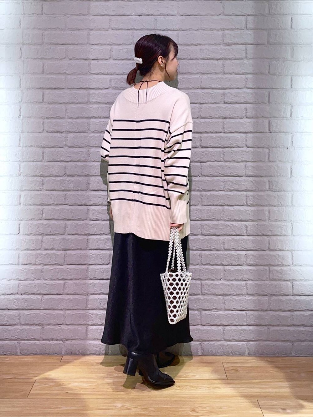 その他のニット/セーター、ブラック系のパンプス、ホワイト系のショルダーバッグを着用したレディースの秋コーディネートの3枚目の写真