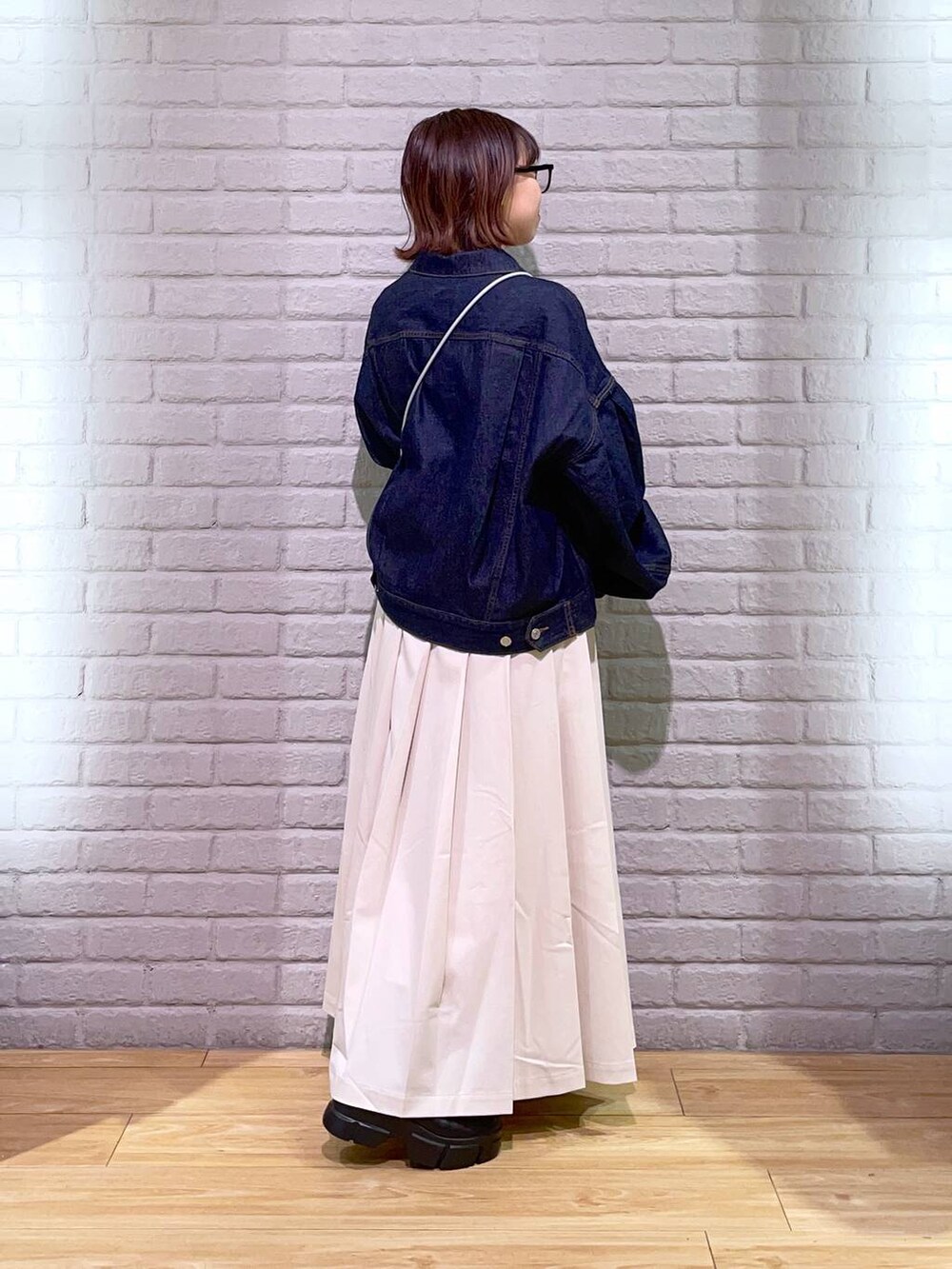 ホワイト系のTシャツ/カットソー、ブラック系のブーツ、ブルー系のデニムジャケットを着用したレディースの秋コーディネートの3枚目の写真