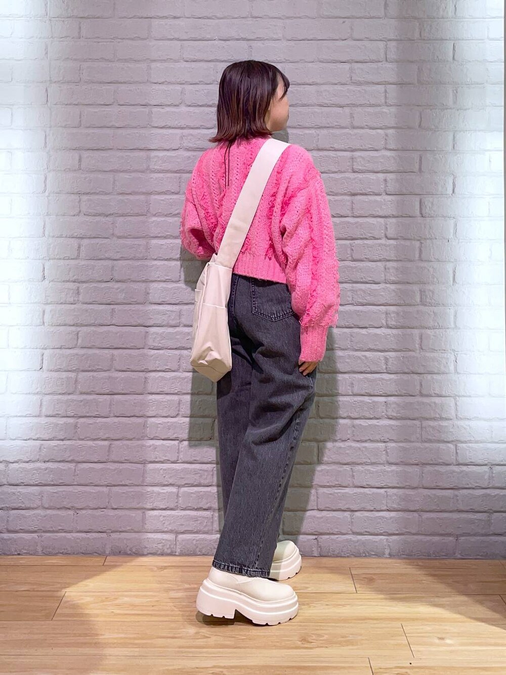 ホワイト系のボディバッグ/ウエストポーチ、ブラック系のデニムパンツ、ホワイト系のブーツを着用したレディースの秋コーディネートの3枚目の写真