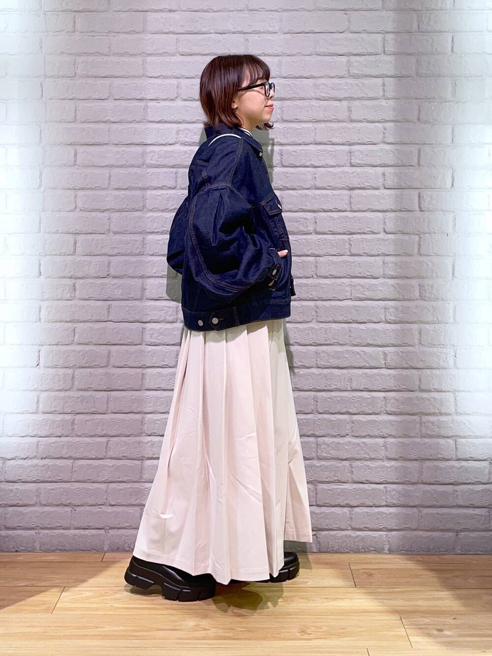 ホワイト系のTシャツ/カットソー、ブラック系のブーツ、ブルー系のデニムジャケットを着用したレディースの秋コーディネートの2枚目の写真