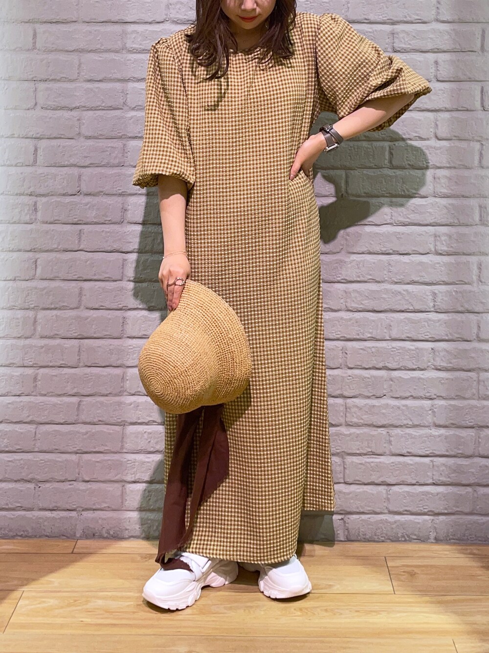 ブラウン系のワンピース、ホワイト系のサンダル、ベージュ系のハットを着用したレディースの春コーディネートの2枚目の写真