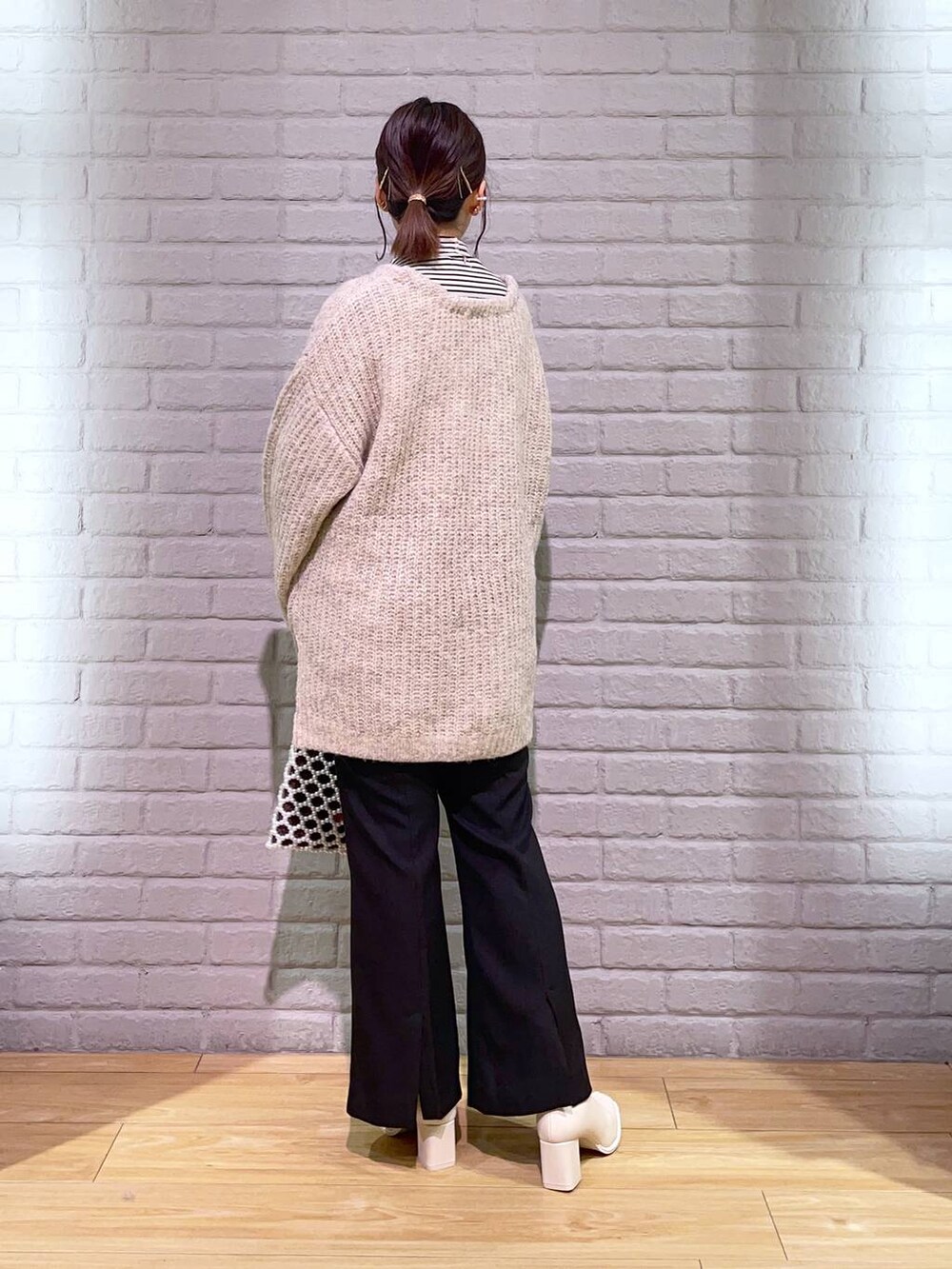 ホワイト系のTシャツ/カットソー、ホワイト系のパンプス、ホワイト系のショルダーバッグを着用したレディースの秋コーディネートの4枚目の写真