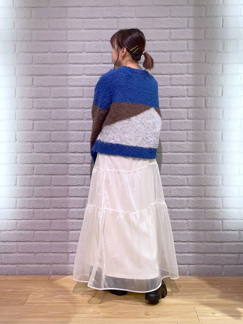 ブラック系のブーツ、ブラウン系のニット/セーター、ブラック系のボストンバッグを着用したレディースの秋コーディネートの3枚目の写真